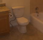 Toliet Next to Cabinet and Tub